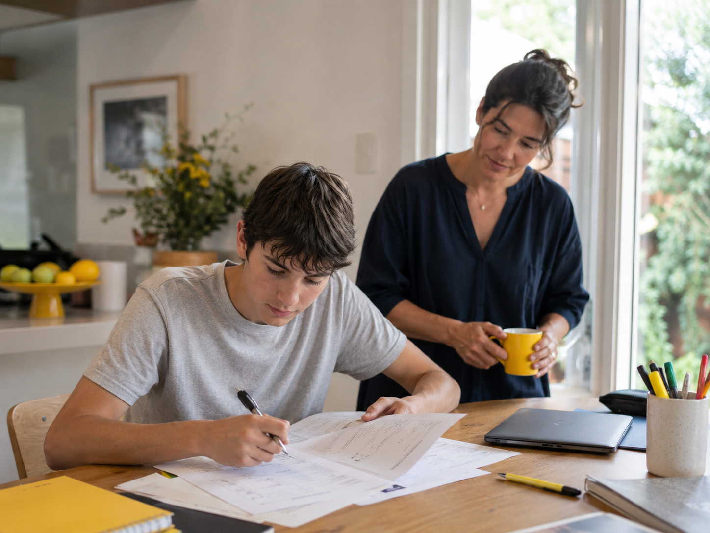 A student working through exam papers with a parent nearby